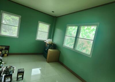 A simple bedroom with green walls and tiled floor.