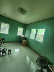 A simple bedroom with green walls and tiled floor.