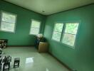 A simple bedroom with green walls and tiled floor.