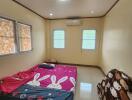 A simple bedroom with a mattress on the floor, air conditioning, and small windows