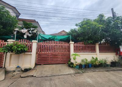 House with green gate and plants