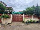 House with green gate and plants