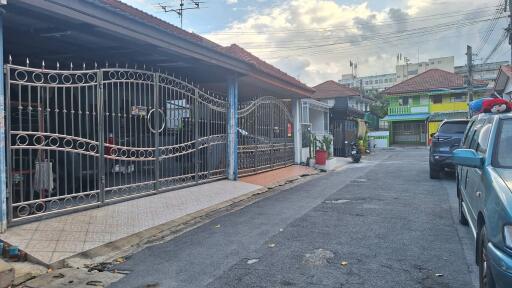 Exterior view of residential houses with gated entrances and a street