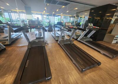 Well-equipped gym with treadmills and reflective mirrors.