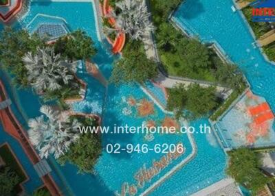 Aerial view of a luxurious outdoor pool area with various pools and lush greenery