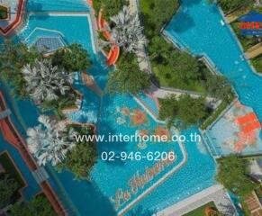 Aerial view of a luxurious outdoor pool area with various pools and lush greenery