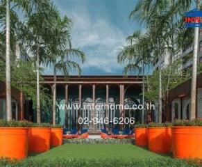 Outdoor area with large orange planters and palm trees in front of a building