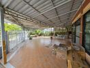 Spacious covered outdoor area with tiled flooring and garden view