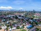 Aerial view of a city showing various buildings, houses, and greenery on a clear day