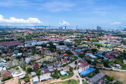 Aerial view of a city showing various buildings, houses, and greenery on a clear day