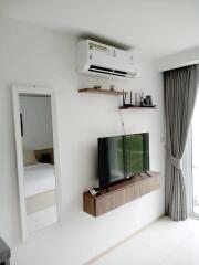 Modern living area with TV, shelving, and air conditioner