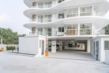 Modern white multi-story condominium with balconies