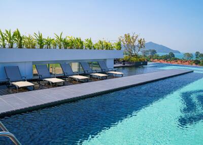 Infinity pool with sun loungers and mountain view