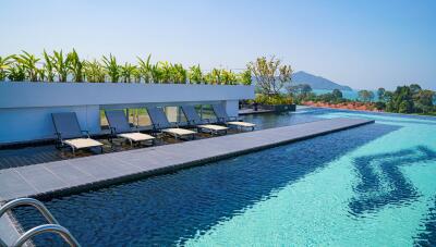 Infinity pool with sun loungers and mountain view