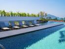 Infinity pool with sun loungers and mountain view