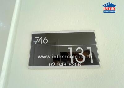 Entrance door sign with room number and website