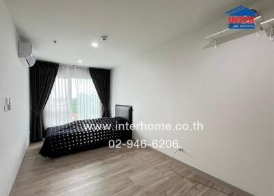 Modern bedroom with single bed, air conditioner, window with curtains, and wooden flooring