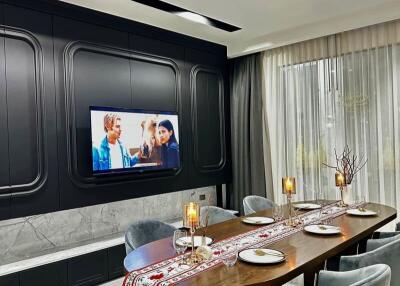 Modern dining area with table set for four and wall-mounted TV