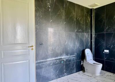 Modern bathroom with marble-patterned walls and a white toilet