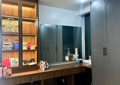 Dressing room with mirror, shelves, and cabinets