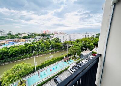 Balcony view overlooking a river and parking lot