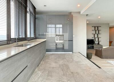 Modern kitchen with large windows and grey cabinetry