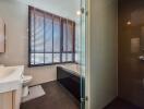 Modern bathroom with bathtub, shower, vanity, and window blinds