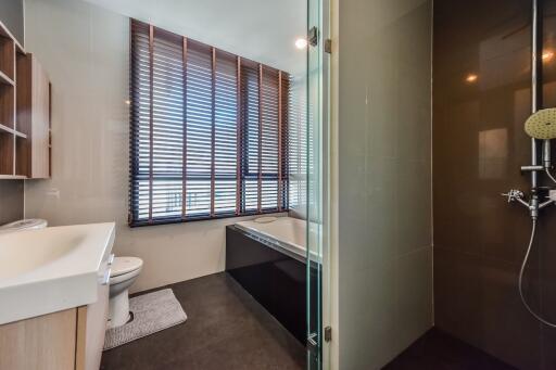 Modern bathroom with bathtub, shower, vanity, and window blinds