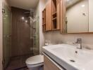 Modern bathroom with glass shower and wooden cabinets