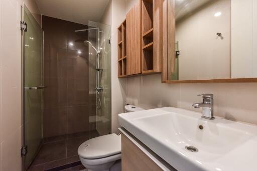 Modern bathroom with glass shower and wooden cabinets