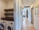 Hallway with laundry area and view to kitchen and living area