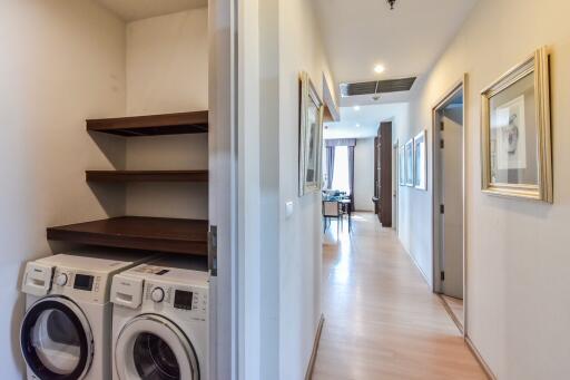 Hallway with laundry area and view to kitchen and living area