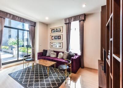 Modern living room with large windows and purple sofa