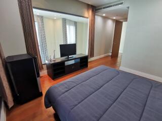 Well-furnished modern bedroom with a television and large windows