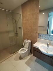 Modern bathroom with glass shower enclosure, toilet, and sink