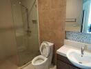 Modern bathroom with glass shower enclosure, toilet, and sink