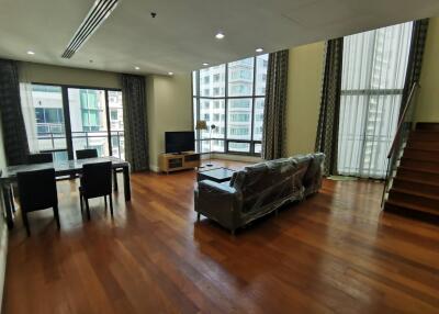 Spacious living room with large windows and wooden flooring