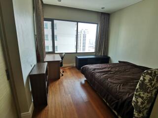 Bedroom with large window, bed, desk, and chair