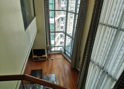 Spacious living room with floor-to-ceiling windows and city view