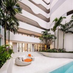 Modern apartment building with pool and lush greenery