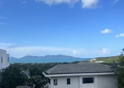 Scenic view of a house overlooking the sea and mountains