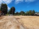 Open land with a dirt road and nearby vegetation