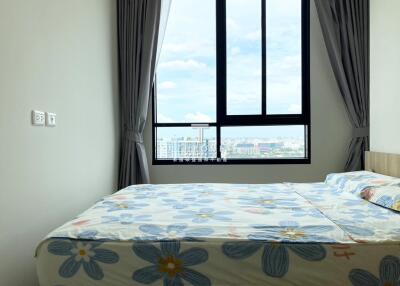 Bedroom with large window and city view