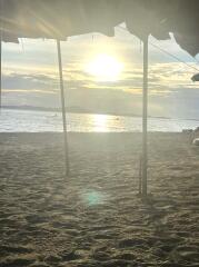 Sunset view of a beach from under a roofed structure