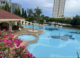 Resort-style outdoor swimming pool with floral decoration and lounge chairs