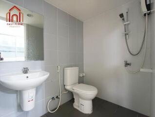 Modern bathroom with white fixtures and wall-mounted shower