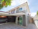 Two-story house exterior with carport and tiled driveway