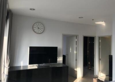 Modern living room with wall-mounted TV and clock