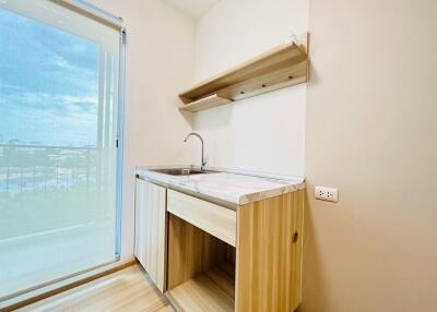 Compact kitchen with wooden cabinets and sliding glass door