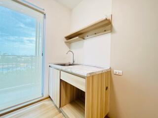 Compact kitchen with wooden cabinets and sliding glass door